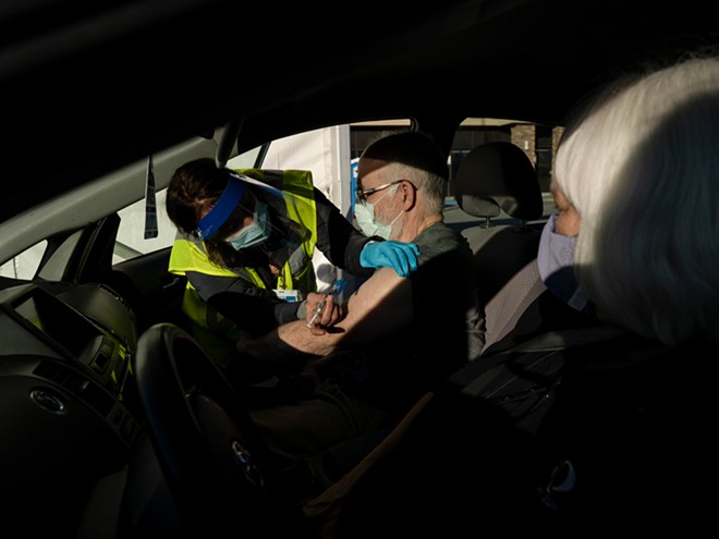 Administering a booster Covid-19 vaccine shot in the Northway Mall parking lot in Anchorage, Alaska, Oct. 24, 2021. So far, boosters aren’t getting to vulnerable people who need them most. The government’s muddled messaging is partly to blame, experts said. - ASH ADAMS/THE NEW YORK TIMES