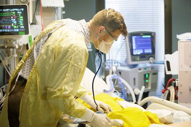 Dr. Ben Arthurs, Critical Care Medical Director at MultiCare Deaconess Hospital, examines a patient in the COVID-19 ICU on Sept. 17, 2021. - YOUNG KWAK PHOTO