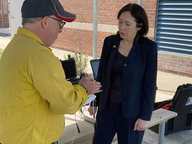 Incident meteorologist Jon Fox, based in Spokane at the National Weather Service, shows U.S. Sen. Maria Cantwell the equipment attached to a weather balloon that provides information such as temperature, humidity, dew points and indicators of wind direction shifts. Incident meteorologists release up to one weather balloon per day when on the scene of a fire to help keep firefighters informed of changing conditions, Fox says. - SAMANTHA WOHLFEIL PHOTO