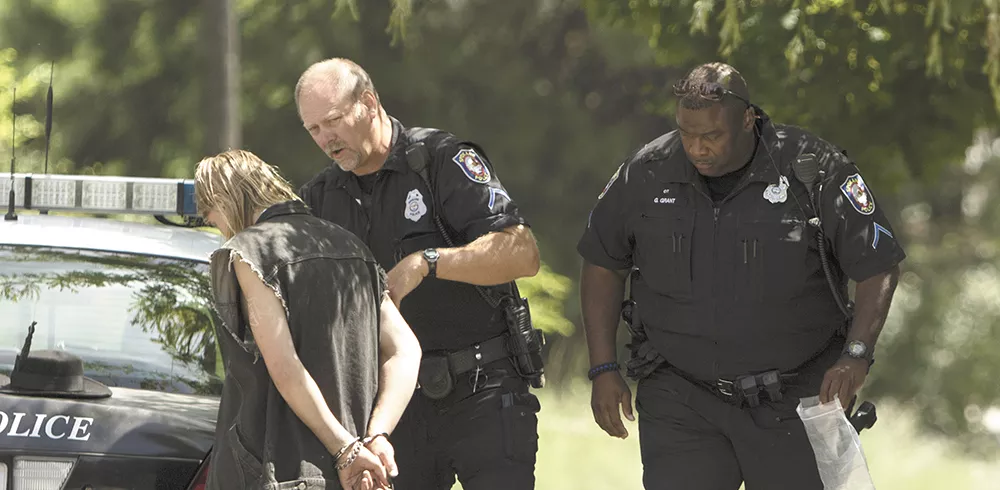 Officer Gordon Grant, right, assists Officer Dave Kennedy as he arrests an unidentified suspect wanted on obstruction of justice warrant. - YOUNG KWAK