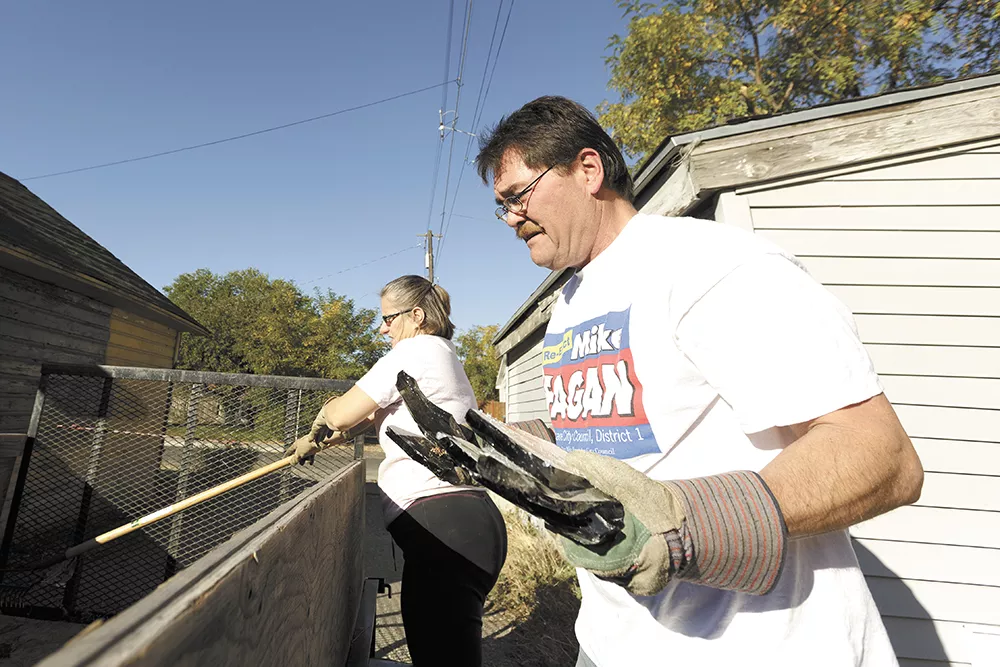 Spokane City Councilman Mike Fagan (right) along with his wife, Donna, load trash during a neighborhood cleanup event. - YOUNG KWAK