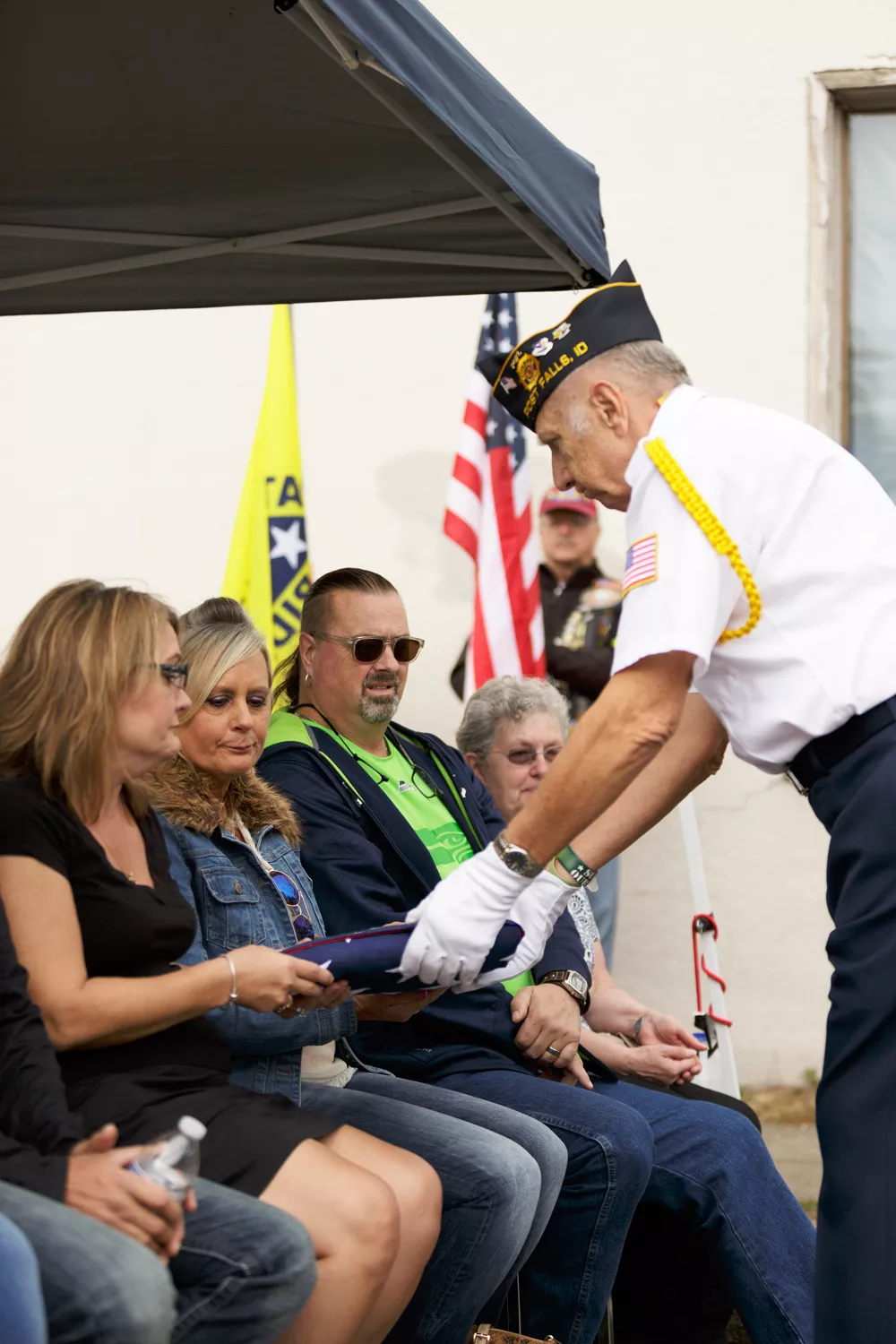 America Legion honor guard member and retired United States Air Force Master Sgt. Harold Mankiewicz, right, hands a flag to Paula Hubeek, left, and Sherry Taylor, second from the left, sisters of Robert Parkinson. - YOUNG KWAK