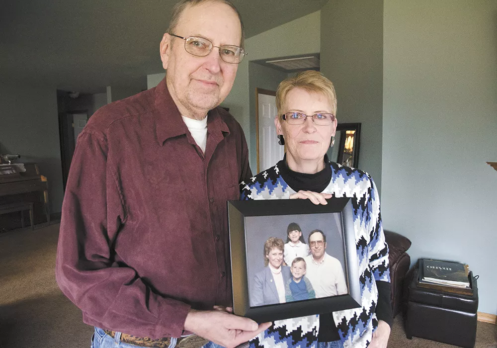 Geri and Sharon Johnson with a family photo with their two adopted children, Megan and Aaron. - JACOB JONES