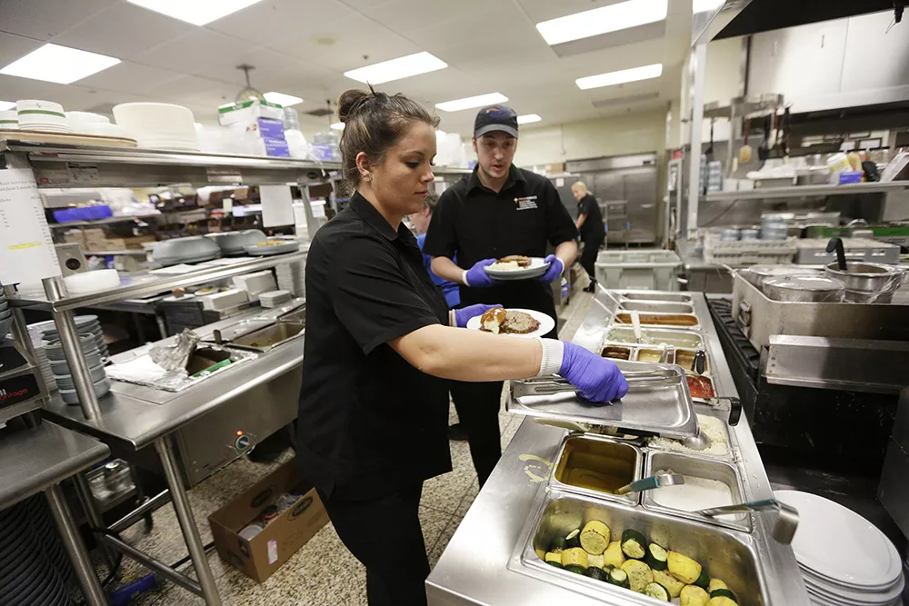 Sarah Rouk and Max Morgan at work in McCampbell's busy kitchen. Local fruit is on offer in the cafeteria whenever possible. - YOUNG KWAK