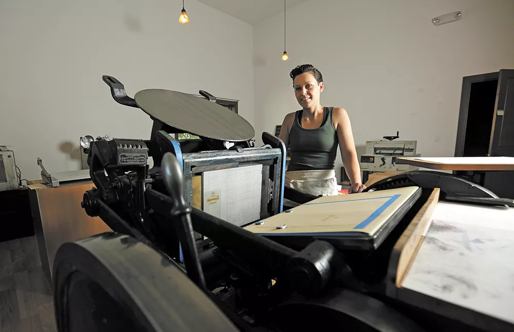 Breanna White with her main press, a 1926 machine she restored to working condition two years ago. - YOUNG KWAK