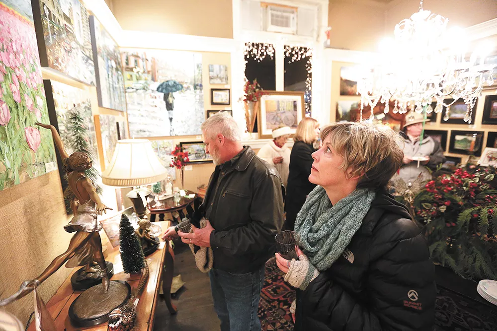 Dorey Rowland looks at Arlon Rosenoff's "April Tulips" as her husband, Bruce Rowland, checks out sculptures at Angel Gallery of Fine Art & Antiques during the monthly Coeur d'Alene Art Walk. - YOUNG KWAK