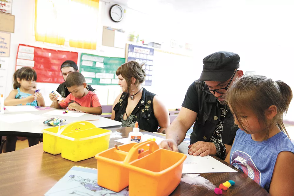 Dan Elliott and 5-year-old Kiaayo (right) work on art projects during a kindergarten class at the Salish School of Spokane. - YOUNG KWAK