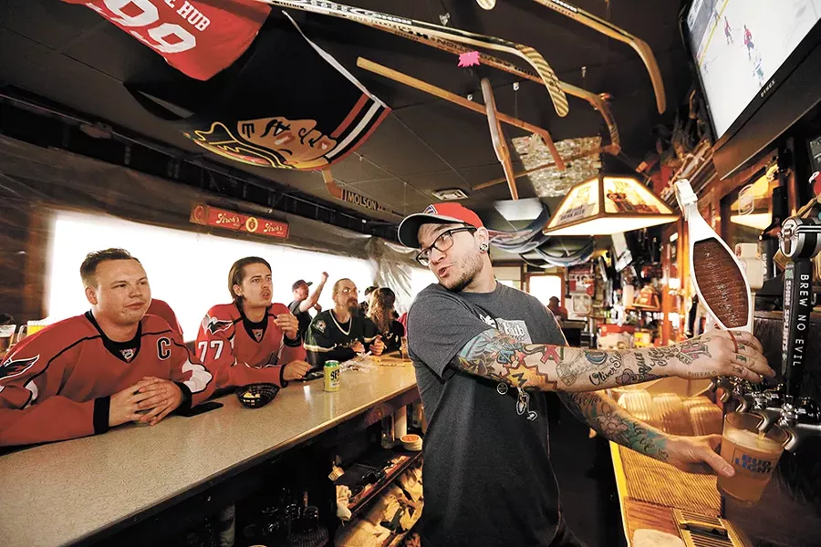The Hub Tavern co-owner Buddy Richardson pulls a beer for hockey lover Greg Kvasov. - YOUNG KWAK