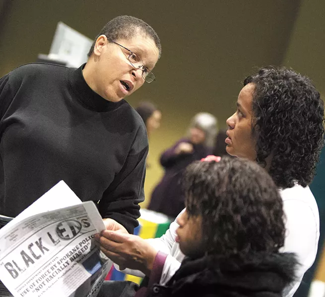 The editor and publisher of the Black Lens, Sandy Williams, left, speaks with Charlotte Lewis and her daughter at a Martin Luther King, Jr. Day rally. - YOUNG KWAK