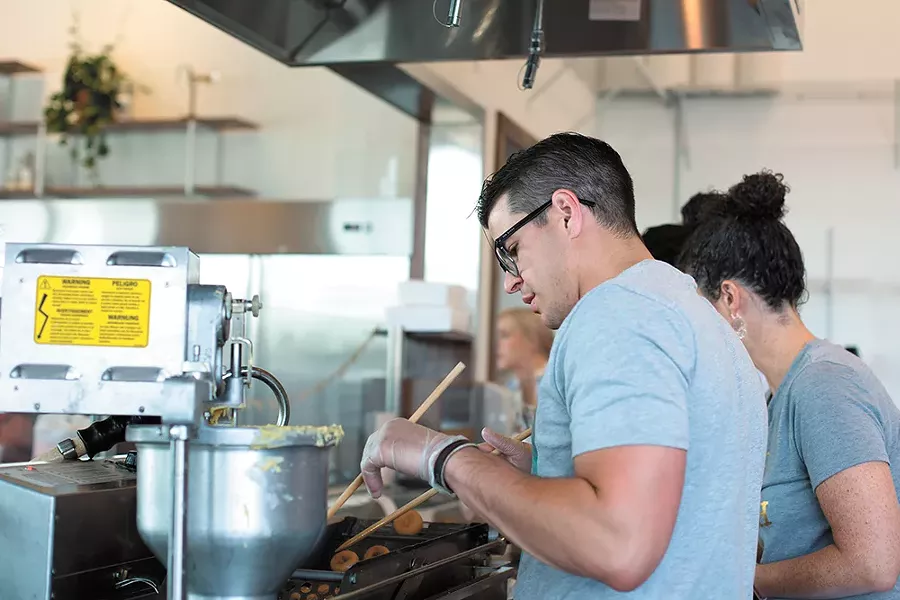 Hello Sugar, co-owner Ramsey Pruchnic works the fresh doughnut line. - TESS FARNSWORTH PHOTO