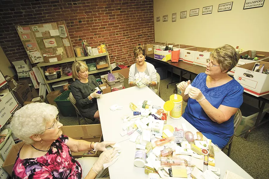 Volunteers with Project Beauty Share organize donated personal-care items. - YOUNG KWAK