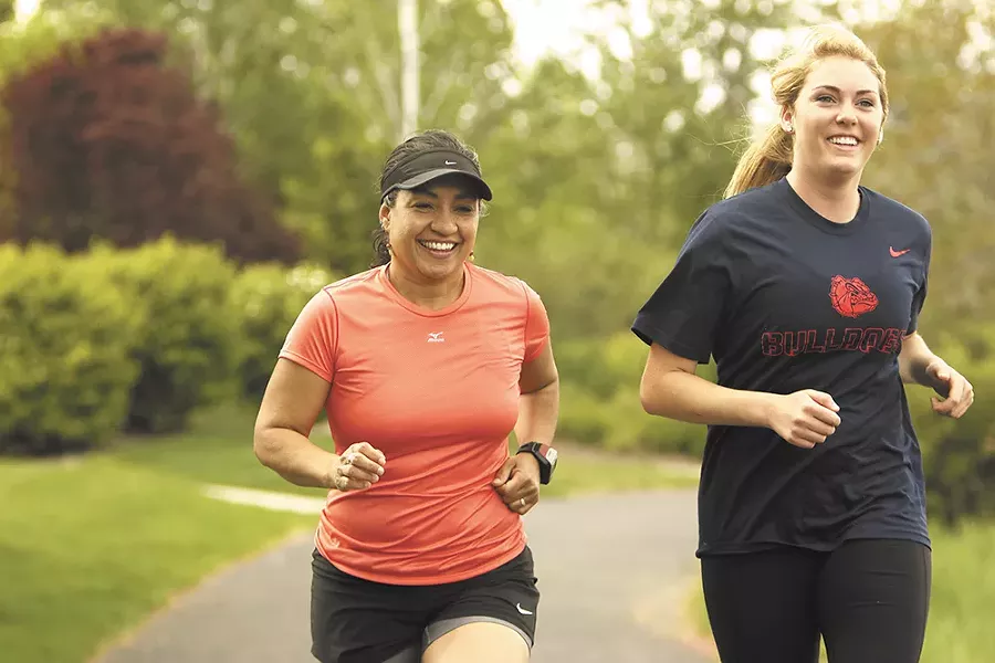 Karen Rickel (left), Gonzaga University assistant professor and chair of the department of sport and physical education, running with recent sports management grad Maggie Reingold. - YOUNG KWAK