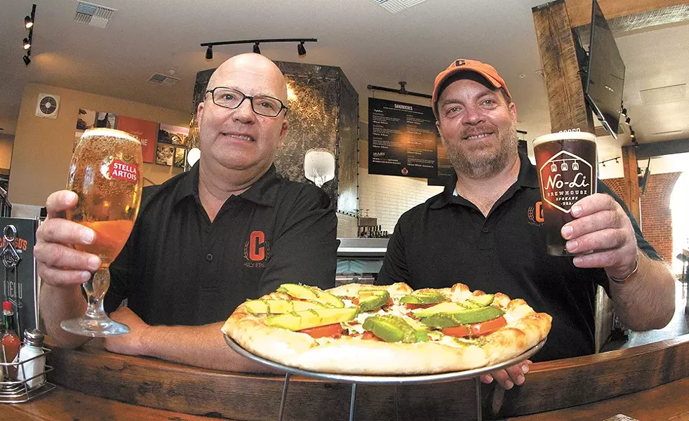 Caruso's Jay Jordan and Vince Caruso celebrate the opening with a cold beer and the Tuscan pizza. - MEGHAN KIRK