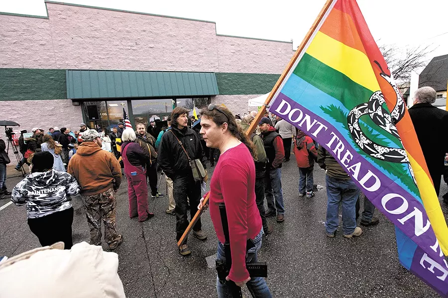 At a December rally protesting police militarization, a demonstrator carries a variation of the Gadsden flag, an American Revolution flag adopted by a variety of right-wing groups. - YOUNG KWAK