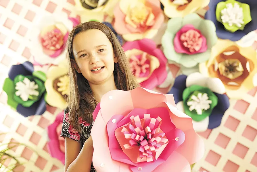 Keira Larson, 9, with paper flowers that she and her family make and sell; proceeds support local animal shelters. - YOUNG KWAK