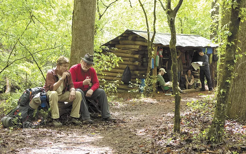 Robert Redford and Nick Nolte cop a squat in the woods.