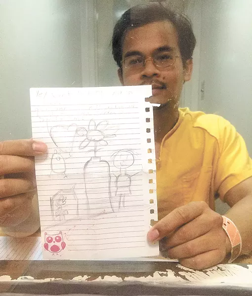 Vy Thang shows a picture his niece drew for him. He talks to his family almost every day, but hasn't seen them in 11 years. - MITCH RYALS