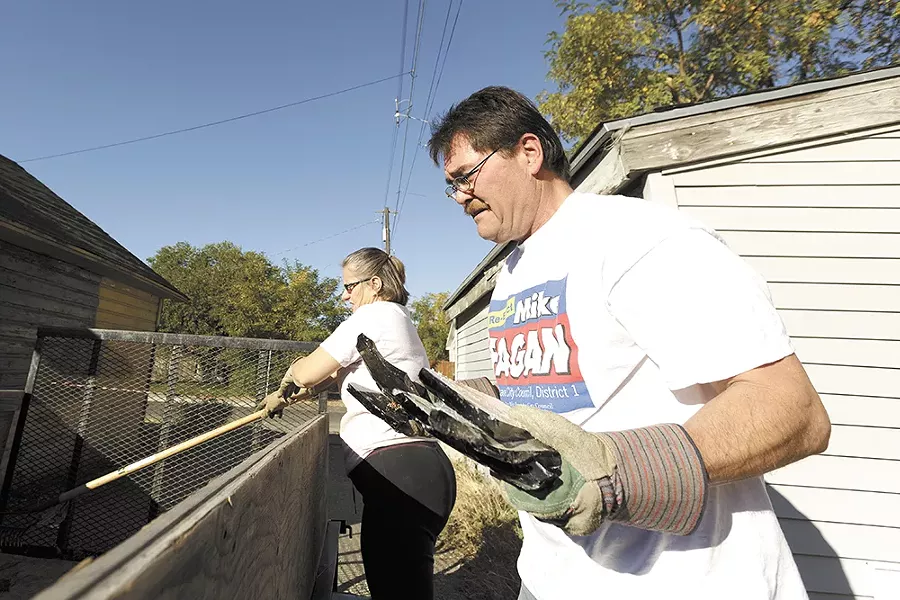 Spokane City Councilman Mike Fagan (right) along with his wife, Donna, load trash during a neighborhood cleanup event. - YOUNG KWAK