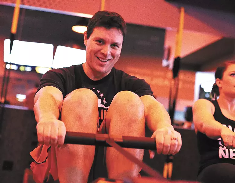 Jason Vestal manages a smile while rowing at Spokane's Orangetheory Fitness. - YOUNG KWAK