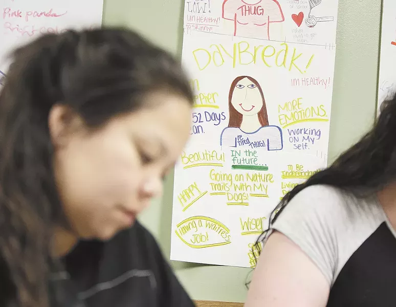 Clients at Daybreak Youth Services concentrate on coloring. In the background is a poster warning of the dangers of meth. - YOUNG KWAK