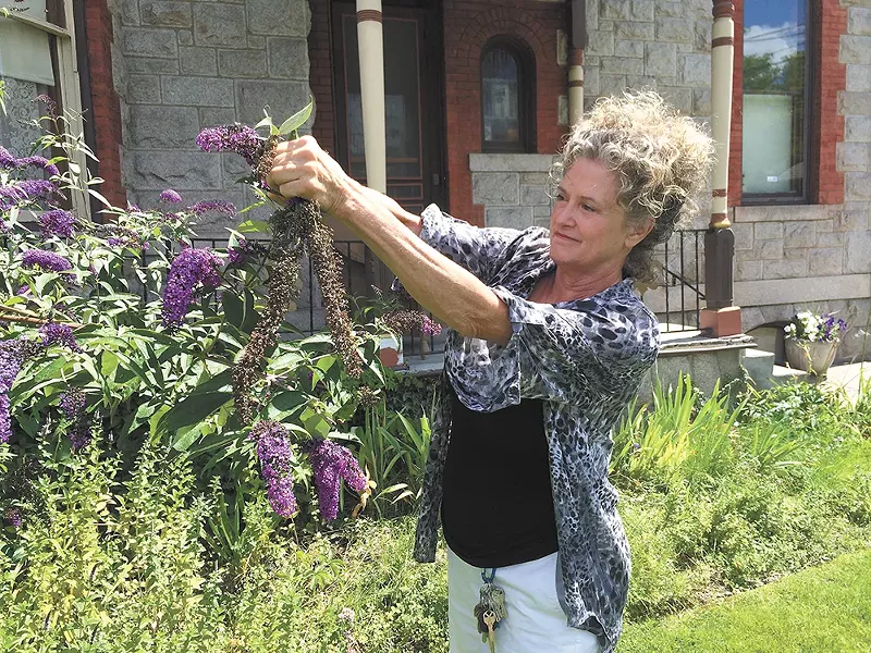 Mary Moltke tidies up the garden of her historic Browne's Addition mansion that she now rents out for events. - MITCH RYALS