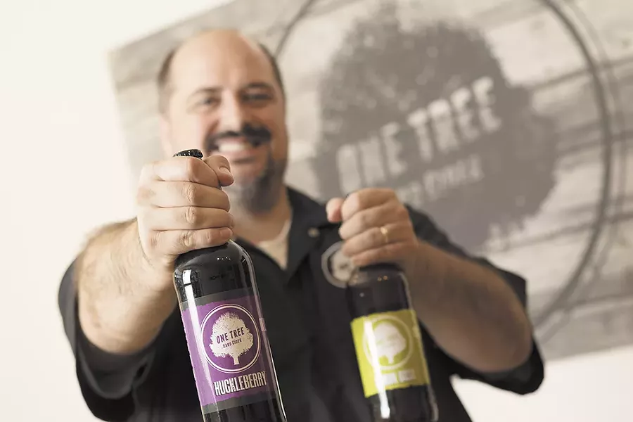 Co-owner Neal Hennessy shows off bottles of One Tree’s hard cider. - YOUNG KWAK