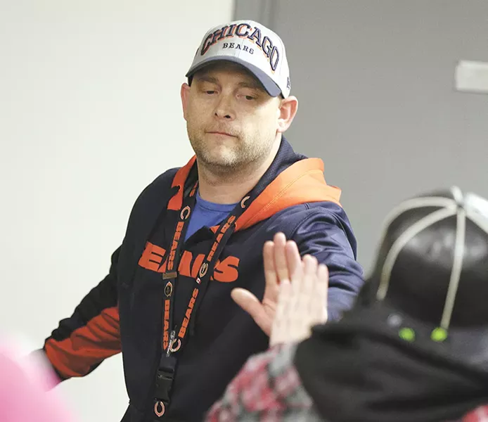 Counselor Jayson Kappen at Daybreak Youth Services high-fives a client in April, shortly after a new funding system for drug treatment centers went into effect.