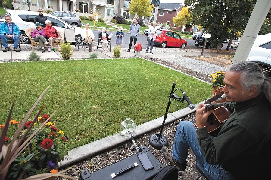 Acoustic guitarist Carlton Oakes plays outside Nick and Michele Follger's West Central home for Porchfest, a music festival aimed at bringing West Central and Kendall Yards together. - NICK FOLLGER