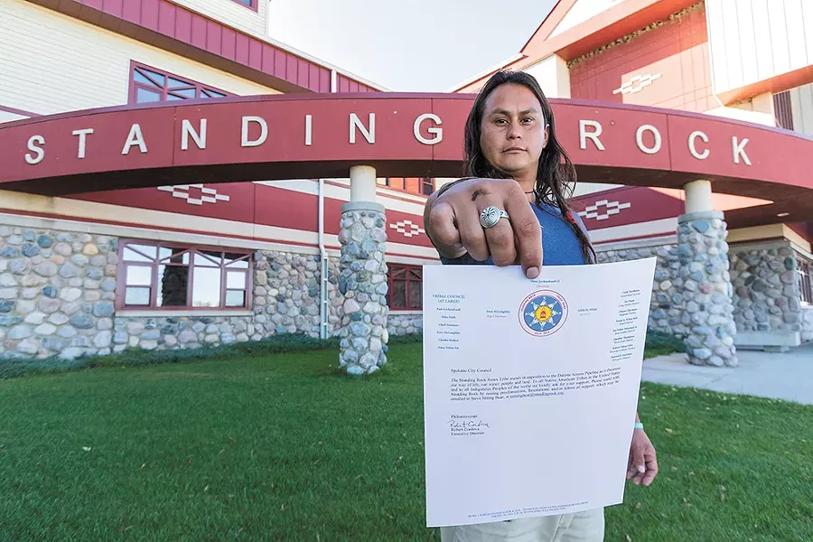 Johns in front of the Standing Rock Sioux Tribe building in North Dakota with a letter from the tribe asking the Spokane City Council to pass a resolution against the DAPL. - JEFF FERGUSON