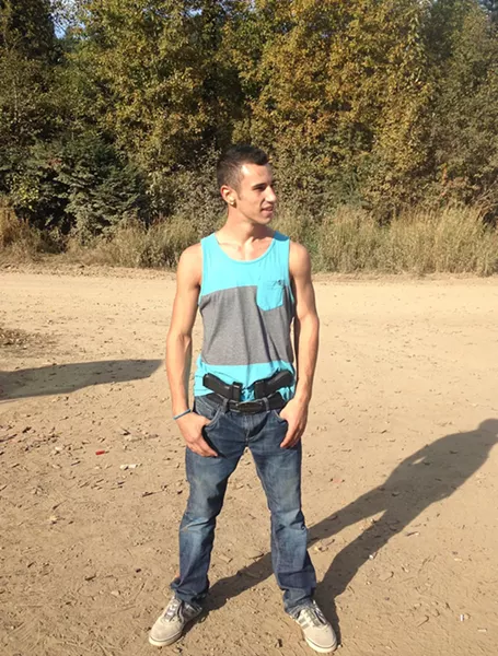 Isaiah Wall poses with one of his favorite things: guns.