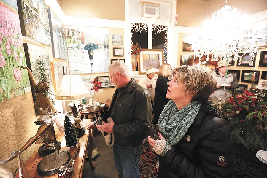 Dorey Rowland looks at Arlon Rosenoff's "April Tulips" as her husband, Bruce Rowland, checks out sculptures at Angel Gallery of Fine Art & Antiques during the monthly Coeur d'Alene Art Walk. - YOUNG KWAK
