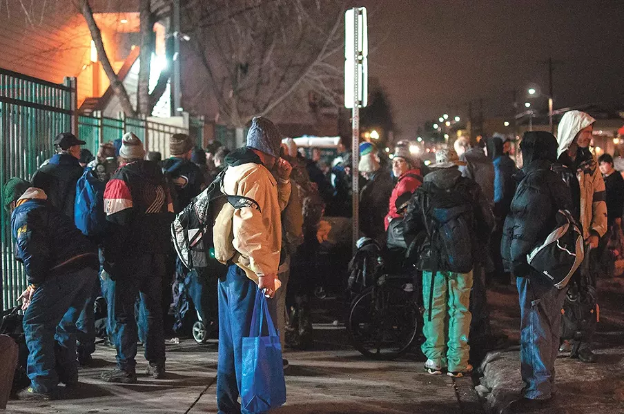 A crowd of homeless men and women gather outside of House of Charity. - DANIEL WALTERS
