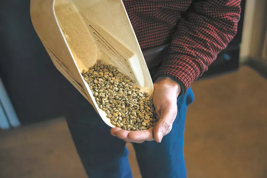 Landgrove Coffee roaster Jon Binninger holds coffee beans that haven't been roasted. - TARYN PHANEUF