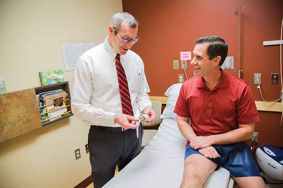 Dr. Kirk Riechard, left, explains the mechanics of hip replacement to patient Paul Kimball. - JENNIFER DEBARROS