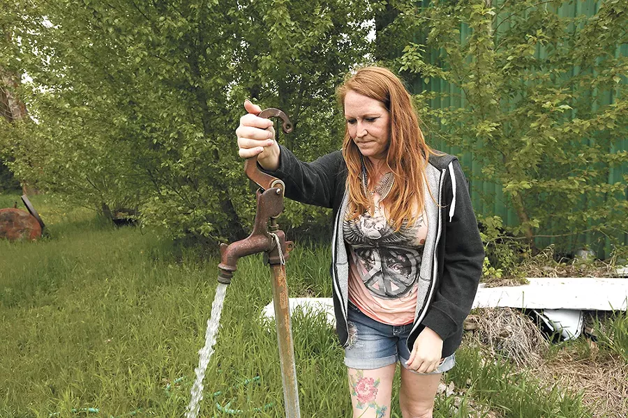 Julie Dibble pumps water from a well, water that her family has been told not to consume. - YOUNG KWAK