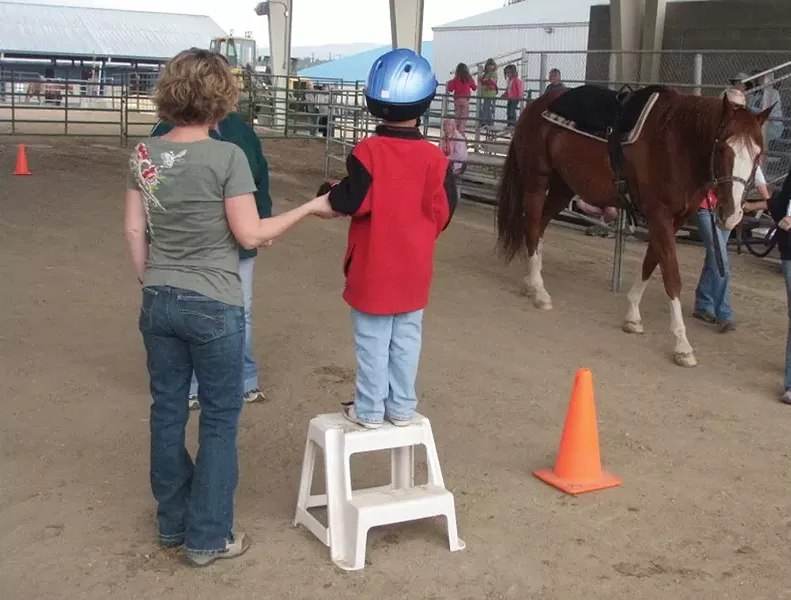 Free Rein volunteer Cyndi Caniglia and a young rider wait for their horse.
