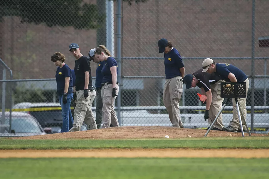 Members of the FBI Evidence Response Team search the field where House Majority Whip Steve Scalise (R-La.) was shoot during a congressional baseball practice at Eugene Simpson Stadium Park in Alexandria, Va., June 14, 2017. After a gunman opened fire on Republicans practicing baseball, lawmakers are pressing to lift regulations on silencers and allow members to carry guns. - AL DRAGO/THE NEW YORK TIMES