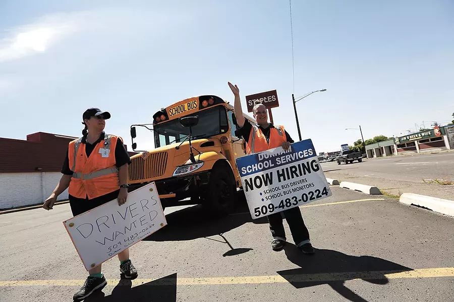 Durham School Services employees, like Kacey Waddell, left, and Christy Lamberson, spend hours at busy intersections in search of the next batch of school bus drivers. - YOUNG KWAK