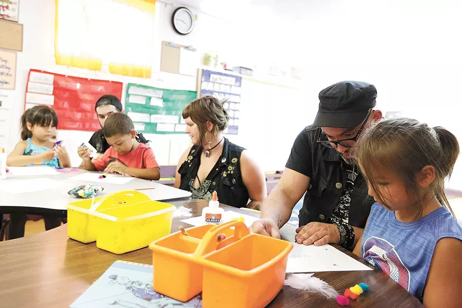 Dan Elliott and 5-year-old Kiaayo (right) work on art projects during a kindergarten class at the Salish School of Spokane. - YOUNG KWAK