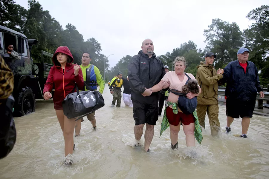 Volunteer and rescue officials help residents to safety after they had to be rescued by boats from their homes after the area flooded in Houston, Aug. 29, 2017. As one of the most destructive storms in the nation’s history pummeled southeast Texas for a fourth day, forecasts on Tuesday called for still more rain, making clear that catastrophic flooding that had turned neighborhoods into lakes was just the start of a disaster that would take years to overcome. - BARBARA DAVIDSON/THE NEW YORK TIMES