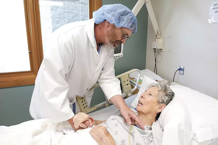 Steve Beckstrom checks on Josephine Johnson, a colon cancer patient, at Lincoln Hospital in Davenport. - YOUNG KWAK