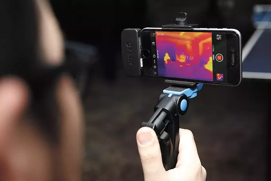 Jacob Lusk uses a FLIR thermal camera attachment during a recent paranormal investigation. - YOUNG KWAK