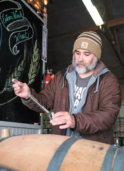 Alex Wilbur at work in the Savage Boar distillery in Airway Heights. - HECTOR AIZON