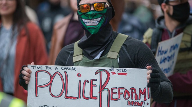 A masked protester calls for police reform in Spokane Sunday.