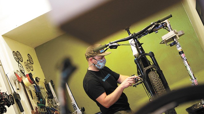 Tim Dunn, the Bike Hub's downtown store manager, works on a customer's bike.