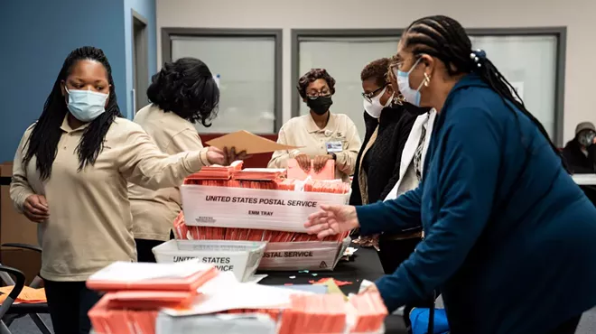 Poll workers sort ballots at the Dekalb County Commissioners office in Decatur, Ga., on Tuesday night, Jan. 5, 2021. Democrats inched closer to taking control of the Senate on Wednesday, winning one of the two Georgia seats up for grabs in a pair of runoff elections while the second contest remained too close to call.