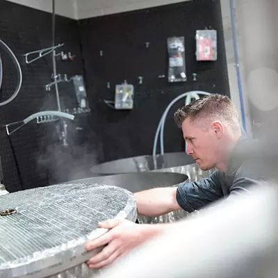 For the Love of God owner and brewer Steve Moss checks his mash tun while brewing a New England-style IPA.