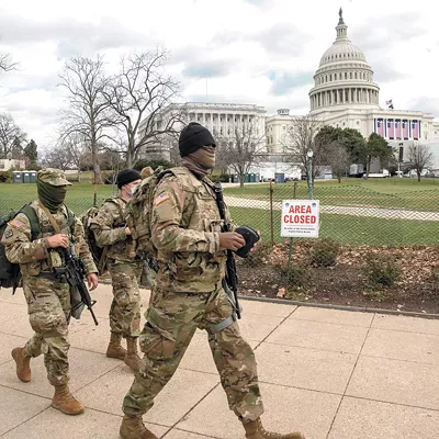 Soldiers assigned to the Virginia Army National Guard walk the fence line near the U.S. Capitol building earlier this week.