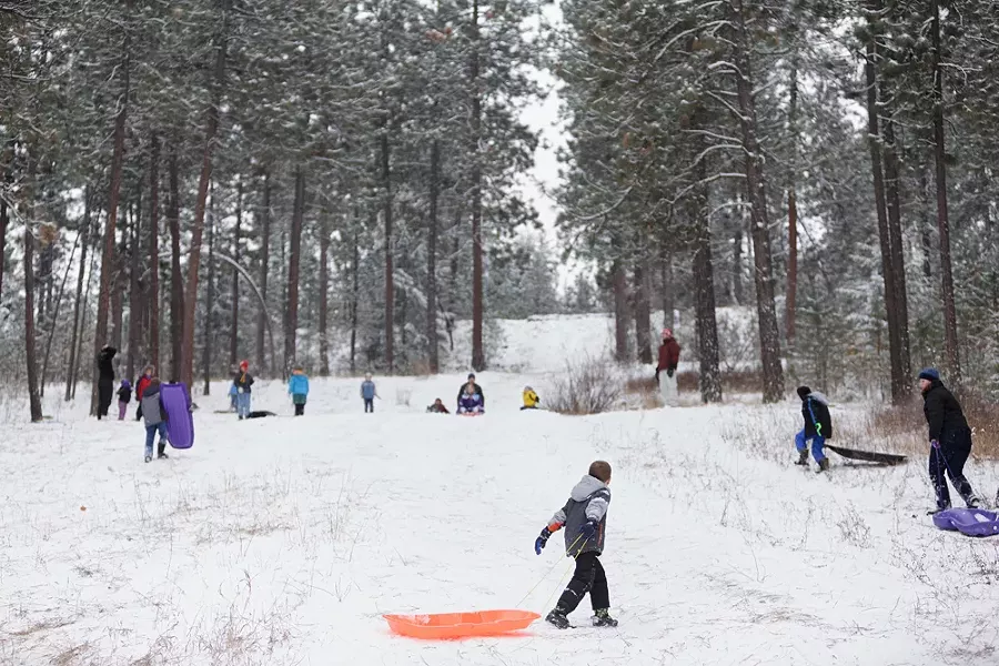 With a few inches of new snow on the ground, people sled at Underhill Park in Spokane. - YOUNG KWAK