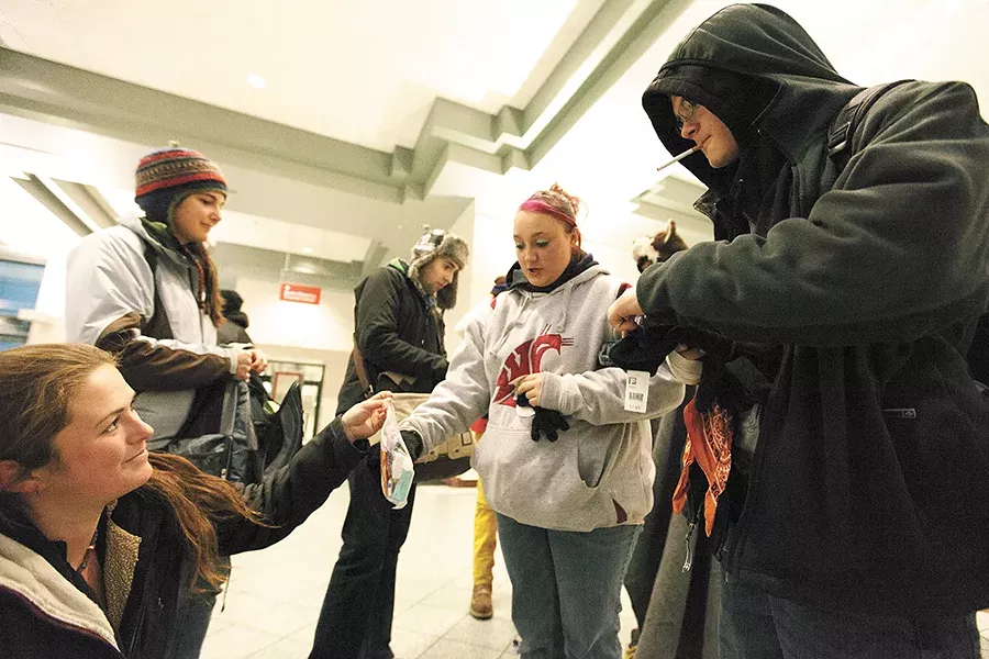 YouthREACH's Carletta Gaston, left, hands out gloves and toiletries at the STA Plaza. - YOUNG KWAK